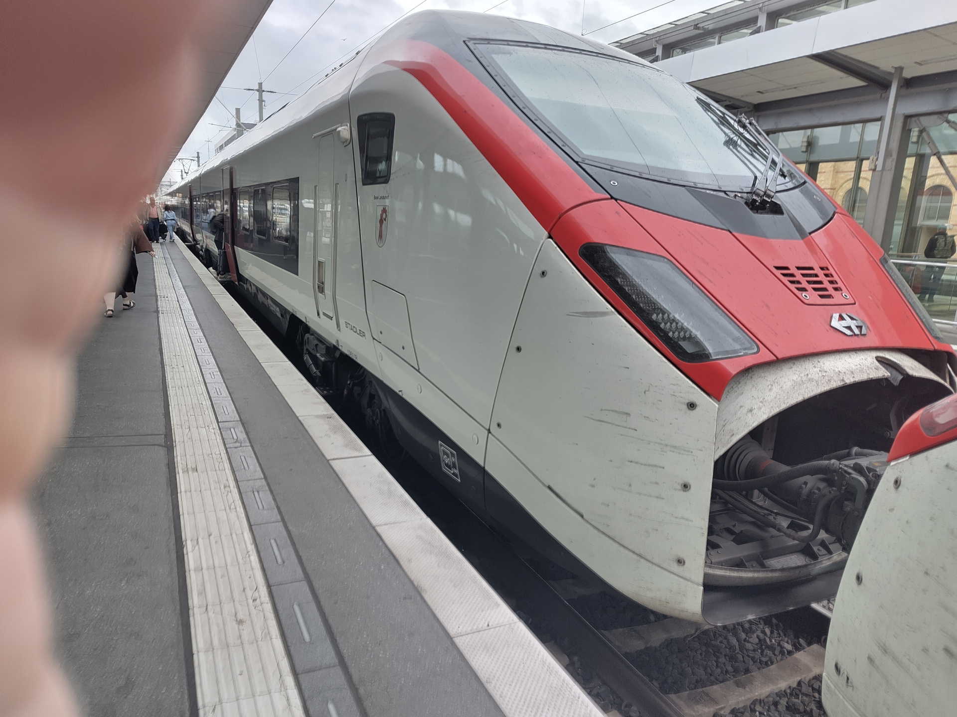 A picture of the front of a train which is connected with another train nose-to-nose. The train has the logo of the SBB (Federal Train Company of Switzerland) on the front. It's also kept in SBB's white and red livery and has the look of a fast, modern high speed train.