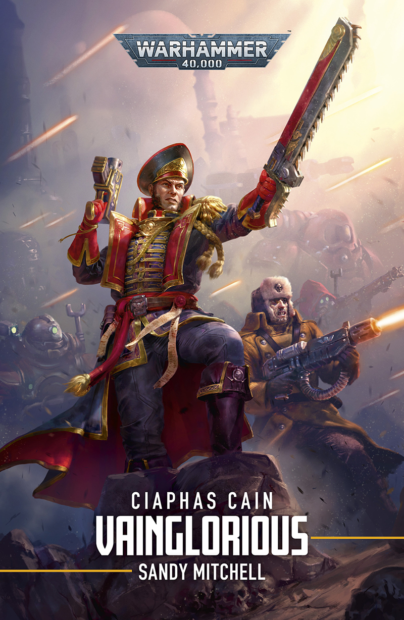 A book cover for the novel Vainglorious by Sandy Mitchell. It shows the titular Comissar Ciaphas Cain standing on a small rock outcrop striking a heroic pose. His left hand is holding a chainsword, outstretched to the front in a 'Get at them!' gesture, while his right holds a laspistol in an easy pose pointed at the sky. He is wearing an elaborate greatcoat adorned with lots of gold braid and the typical Warhammer prayer scrolls. In the background is an Adeptus Mechanicus army, while Cain is flanked by his trusty adjutant, Jurgen.