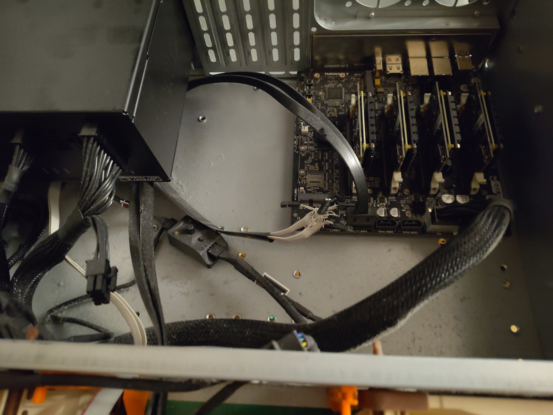 A picture of the TP2 board sitting in a 3U rack case. It has four Raspberry Pi CM4 modules in it. It's connected with a 24-pin ATX connector to a normal ATX power supply. Also connected is part of the front panel header and the internal USB connector. In addition, there's a Noctua fan controller sitting there, connected to two 120mm Noctua fans and powered by one of the SATA rails from the power supply. It is all extremely dusty. As in: You couldn't just write your name in it. You could write the entirety of The Prince in it, with multiple layers.